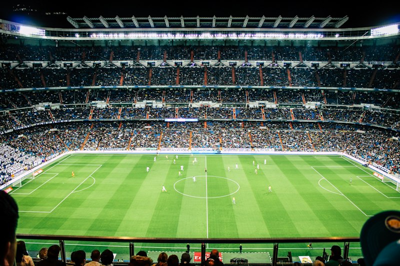 Estádio de futebol iluminado em noite de clássico